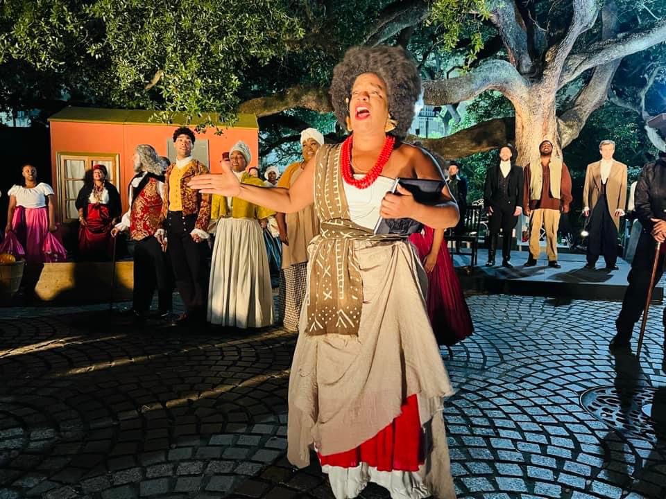 Woman singing with theatrical ensemble outdoors